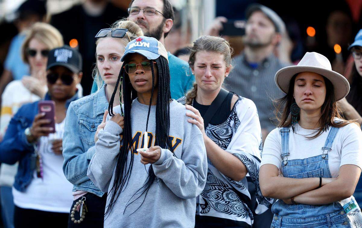 Attendees listen during a candlelight vigil outside the Hedingham clubhouse Saturday, Oct. 15, 2022, for those killed and wounded in a mass shooting in the Hedingham neighborhood in Raleigh, N.C., on Thursday.