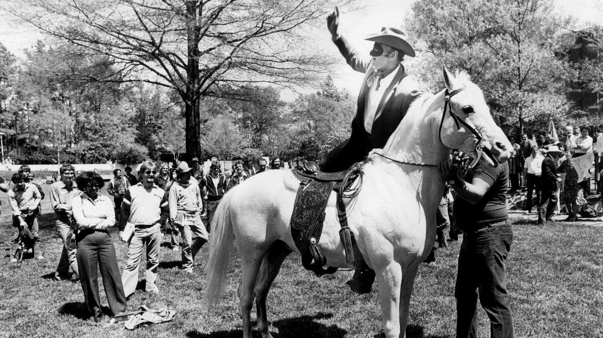 A 1980 photo shows NC State football coach Monte Kiffin, dressed as the Lone Ranger, riding a horse on the lawn of the student center on campus.