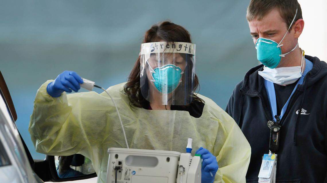 Medical staffers at UNC Hospitals in Chapel Hill, N.C. screen a patient at a drive-thru at the emergency department Wednesday, April 1, 2020. Photo by Scott Sharpe, The News & Observer