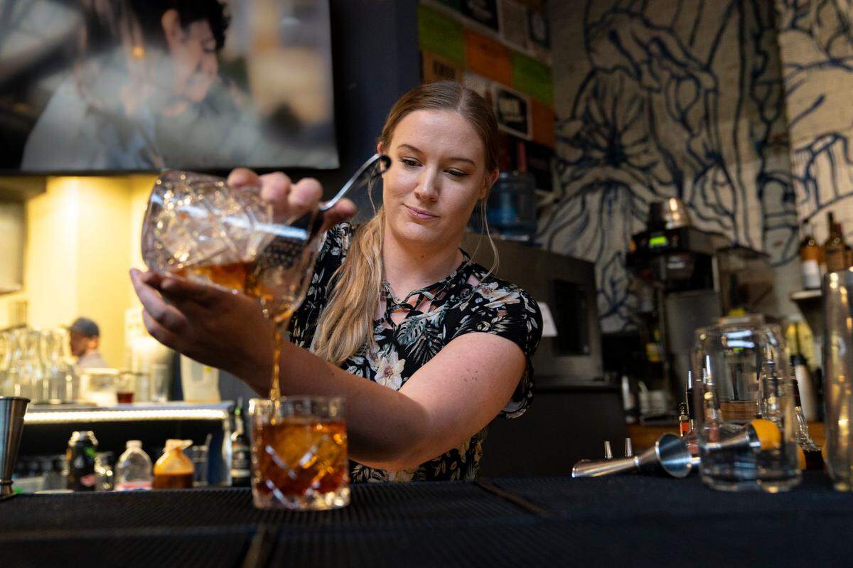 Ingrid Folkers, a bartender at Whiskey Kitchen in downtown Raleigh, N.C. makes an old fashioned on Sunday, June 19, 2022.