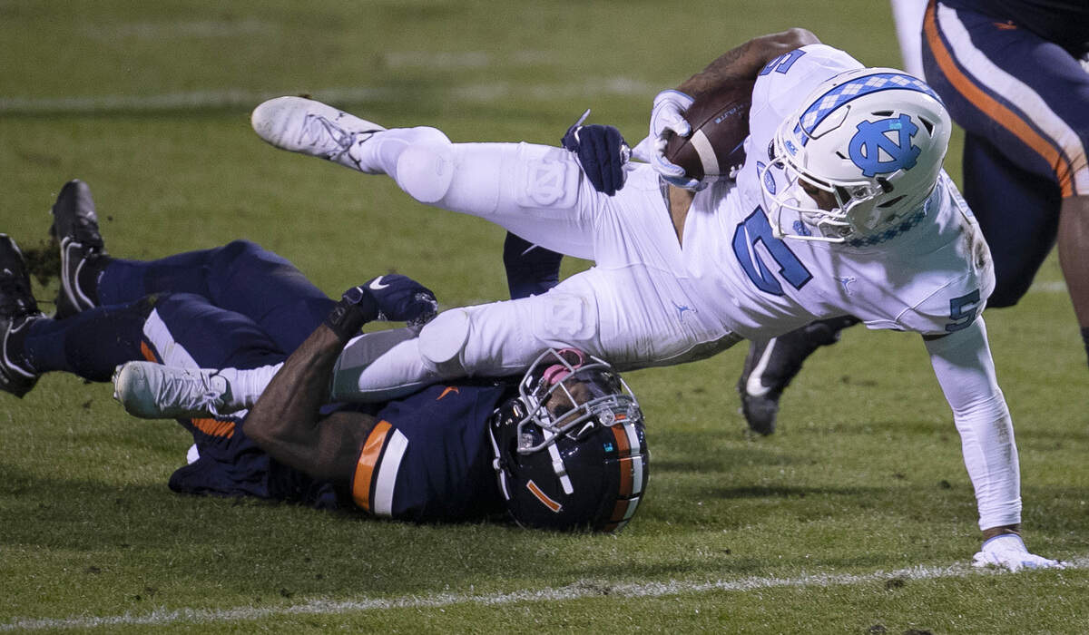 Virginia’s Nick Grant (1) stops North Carolina’s Dazz Newsome (5) after a 29-yard pass reception from quarterback Sam Howell (7) in the second quarter on Saturday, October 31, 2020 at Scott Stadium in Charlottesville, Va.