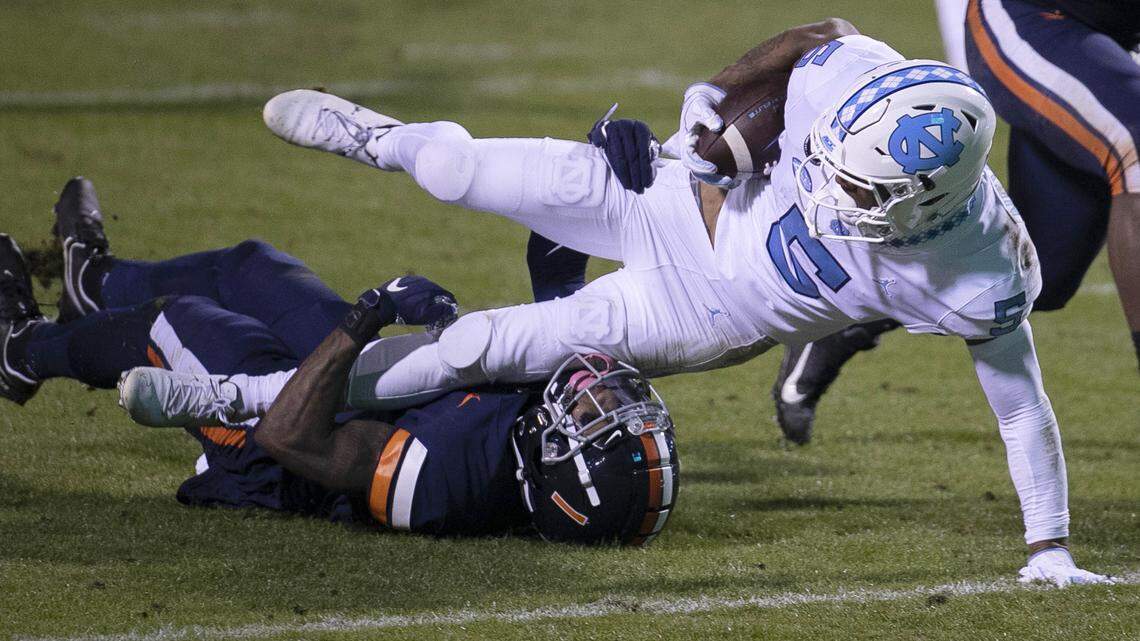 Virginia’s Nick Grant (1) stops North Carolina’s Dazz Newsome (5) after a 29-yard pass reception from quarterback Sam Howell (7) in the second quarter on Saturday, October 31, 2020 at Scott Stadium in Charlottesville, Va.