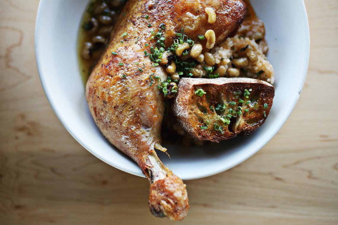 Postmaster's Cast Iron Chicken Leg is made up of sofrito rice, vegetable broth, black eye peas and soppin' bread.