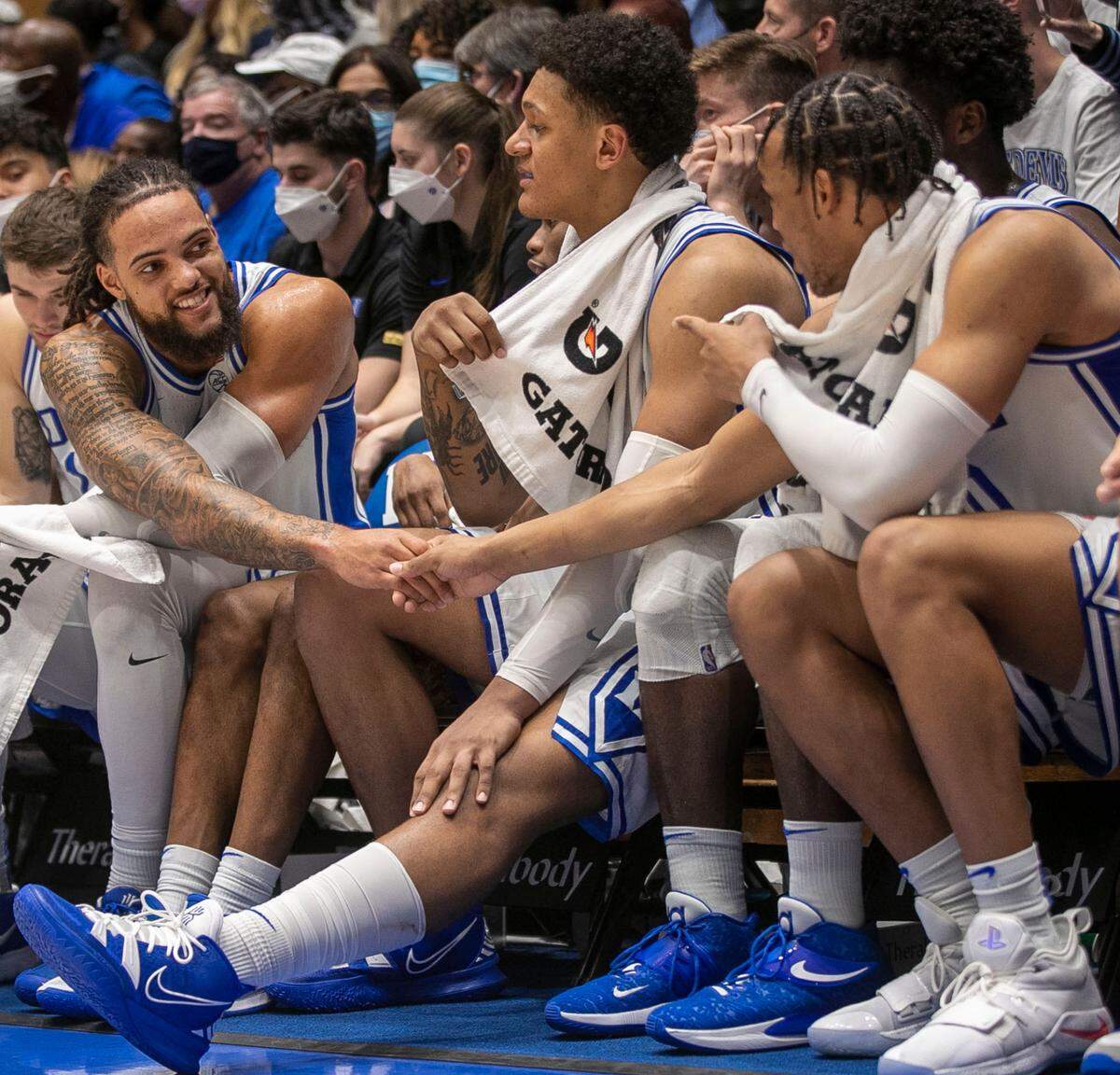 Duke’s Theo John (12) shakes hands with teammate Wendell Moore Jr. (0) during the closing minutes of play against Elon on Saturday, December 18, 2021 at Cameron Indoor Stadium in Durham, N.C.