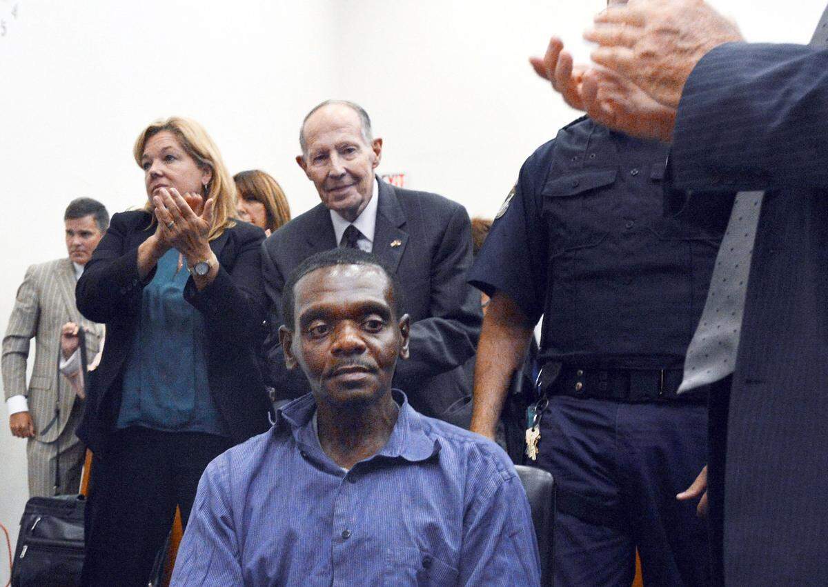 Henry McCollum sits stunned as applause rings out in a Robeson County courtroom in Lumberton, N.C. Tuesday, September 2, 2014 after a judge has declared McCollum and his brother Leon Brown innocent of a brutal rape murder for which they have spent 30 years in prison. The brothers were convicted of the 1983 rape and murder of an 11-year-old girl whose body was found in a soybean field near the tiny town of Red Springs.