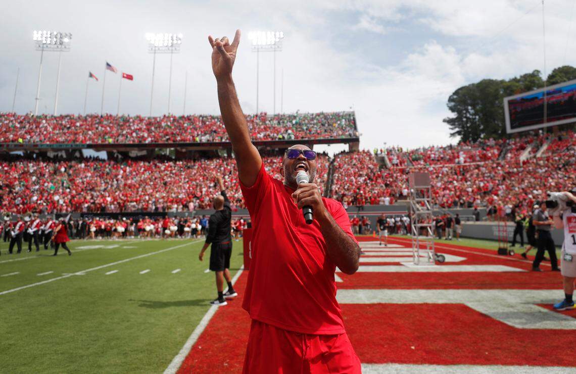 N.C. State legend Torry Holt and his brother, Terrence, background, lead the crowd in the Wolfpack cheer before N.C. State’s game against Notre Dame at Carter-Finley Stadium in Raleigh, N.C., Saturday, Sept. 9, 2023.