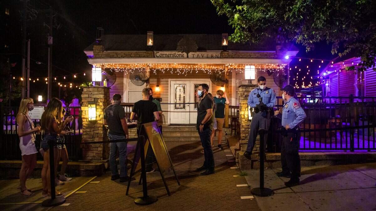 Two Raleigh police officers stand outside the Cornerstone Tavern on Glenwood Avenue on Friday, Jun. 26, 2020, in Raleigh, N.C.