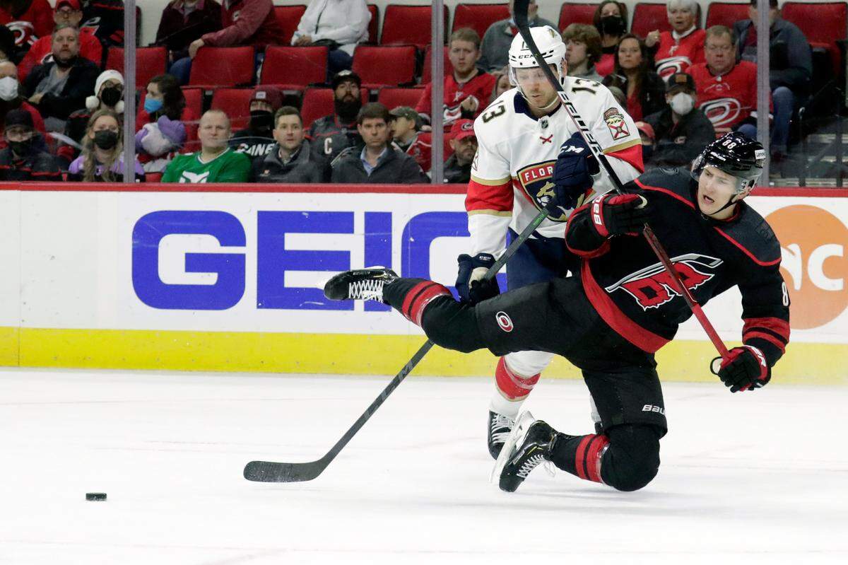 Florida Panthers center Sam Reinhart (13) and Carolina Hurricanes center Martin Necas (88), right, collide as they go for the puck during the first period of an NHL hockey game Wednesday, Feb. 16, 2022, in Raleigh, N.C. (AP Photo/Chris Seward)