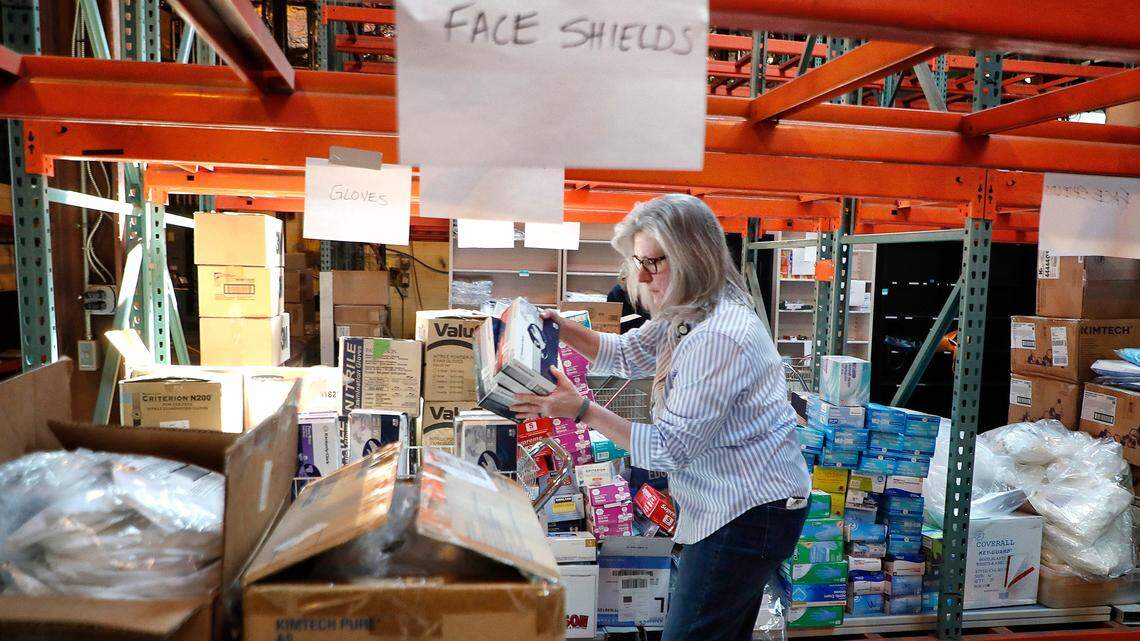 Kathy Willis, R.N., takes donations from the community off the shelves in order to be categorized at the WakeMed Health and Hospitals warehouse in Raleigh, N.C., Monday, March 30, 2020. The categorization determines where the items can be used throughout the hospital. Graybeard Distillery in Durham, MedPharm and Avazyme donated 100 gallons of hand sanitizer Monday.