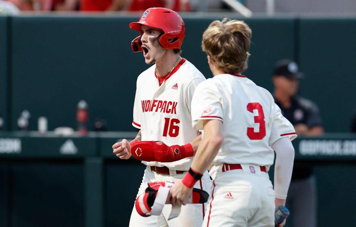 N.C. State’s Eli Serrano III (16) celebrates with Brandon Butterworth (3) after Serrano III scored after the Wolfpack’s Alex Sosa walked with the bases loaded in the seventh inning during N.C. State’s 6-4 victory over South Carolina in the NCAA Raleigh Regional at Doak Field Saturday, June 1, 2024.