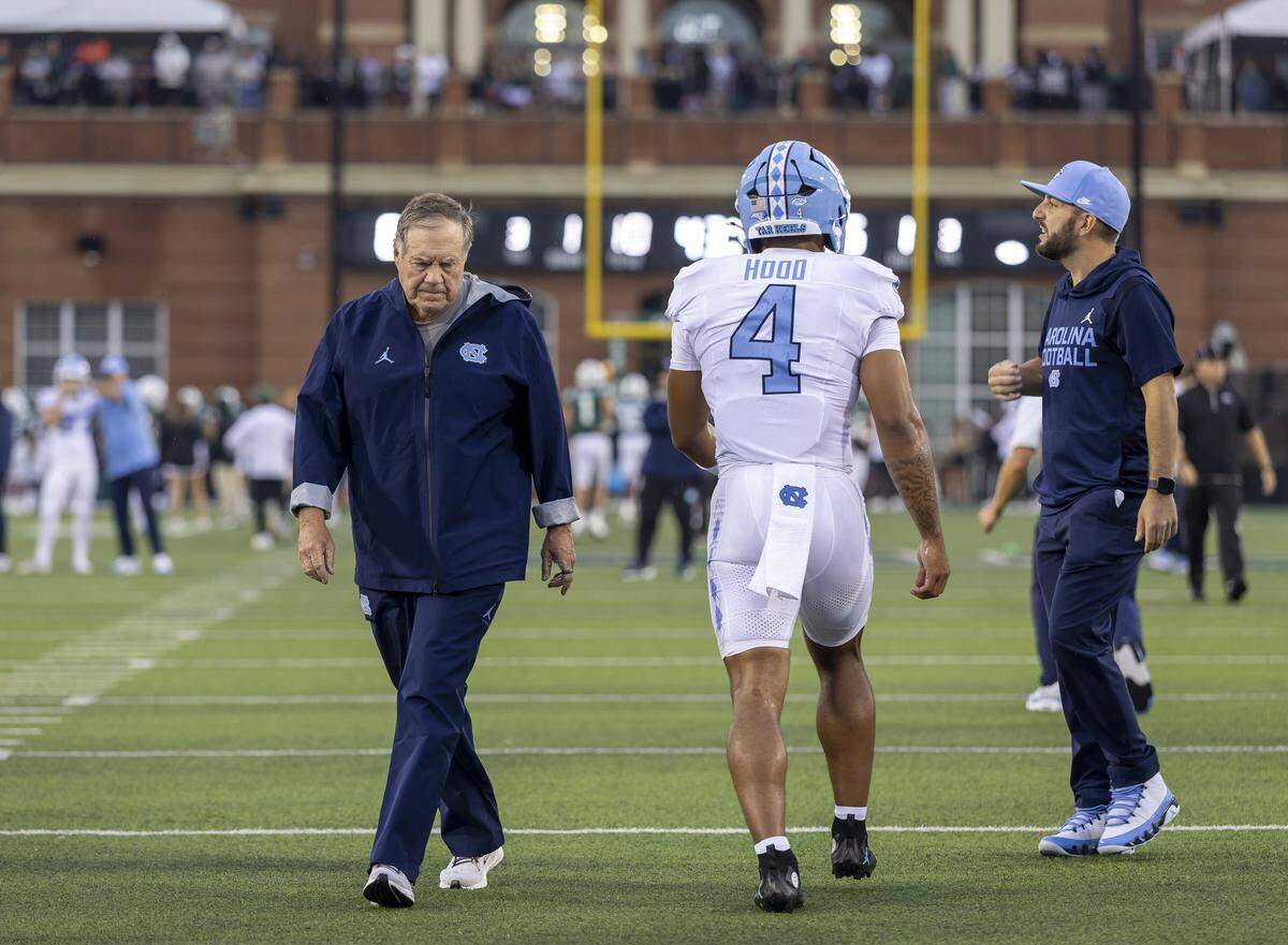 North Carolina coach Bill Belichick, running back Caleb Hood (4), quarterbacks coach Matt Lombardi, warm up for the Tar Heels’ game against UNC Charlotte on Sept. 6 in Charlotte.