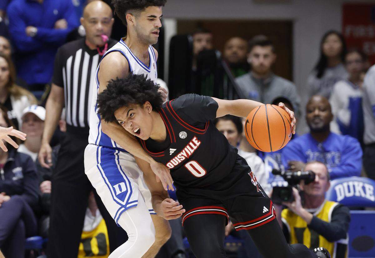 Duke’s Cayden Boozer (2) defends Louisville's Mikel Brown Jr. (0) during the first half of Duke’s game against Louisville at Cameron Indoor Stadium in Durham, N.C., Monday, Jan. 26, 2026.
