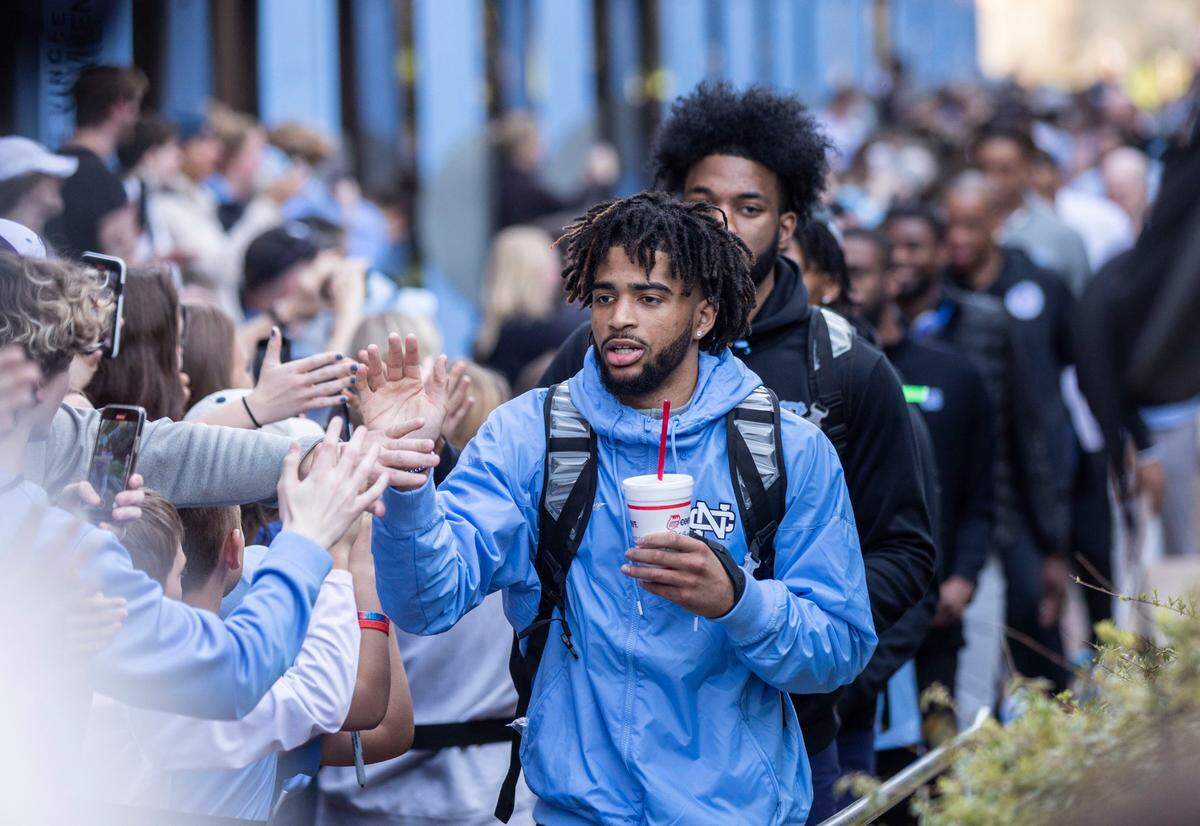 RJ Davis high-fives fans as the UNC basketball team walks towards their bus outside the Dean Dome in Chapel Hill, N.C. to make their way to New Orleans for the Final Four on Wednesday, March 30, 2022.