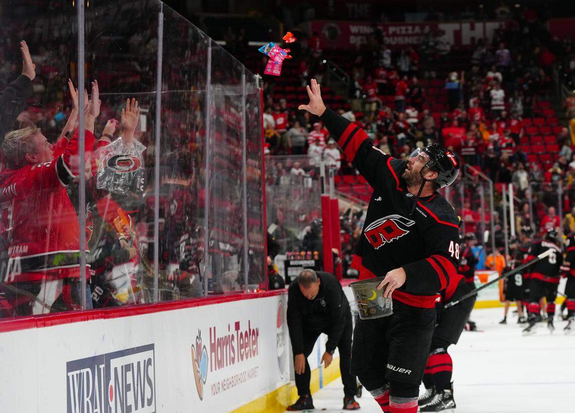 Carolina Hurricanes left wing Jordan Martinook (48) tosses candy to the fans after the game against the Boston Bruins at Lenovo Center.