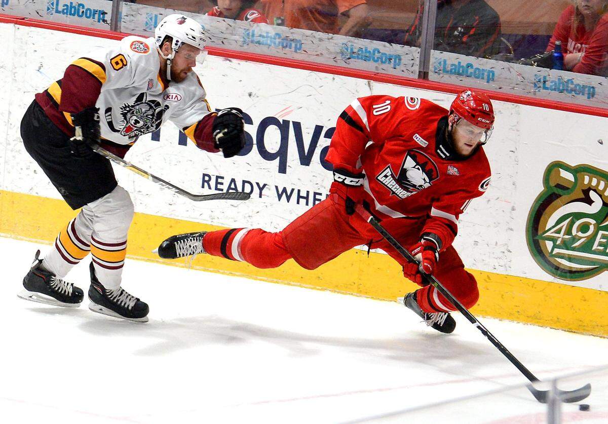 Charlotte Checkers center Steven Lorentz, right, fights to maintain control of the puck while battling Chicago Wolves Griffin Reinhart, left, during first period action on Sunday, June 2, 2019 at Bojangles’ Coliseum in Charlotte, NC.