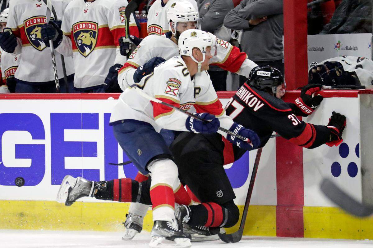 Florida Panthers right wing Patric Hornqvist (70) and defenseman Radko Gudas, back, check Carolina Hurricanes right wing Andrei Svechnikov (37) into the boards during the first period of an NHL hockey game Wednesday, Feb. 16, 2022, in Raleigh, N.C. (AP Photo/Chris Seward)