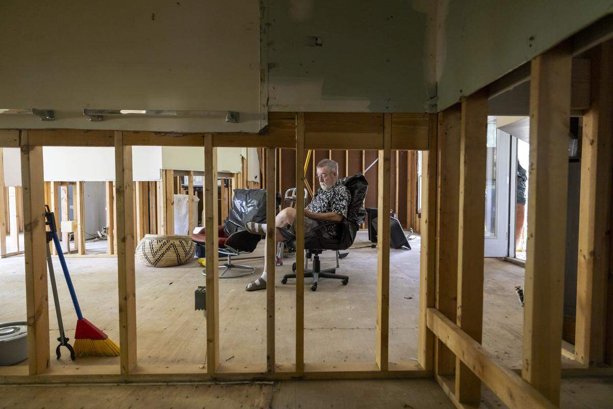 Peter Burke sits in the living room of his flood damaged home in the Weatherhill Pointe neighborhood of Carrboro, N.C. on Friday August 15, 2025. Burke is waiting for contractors to install new dry wall and electrical wiring so he can return to his home.