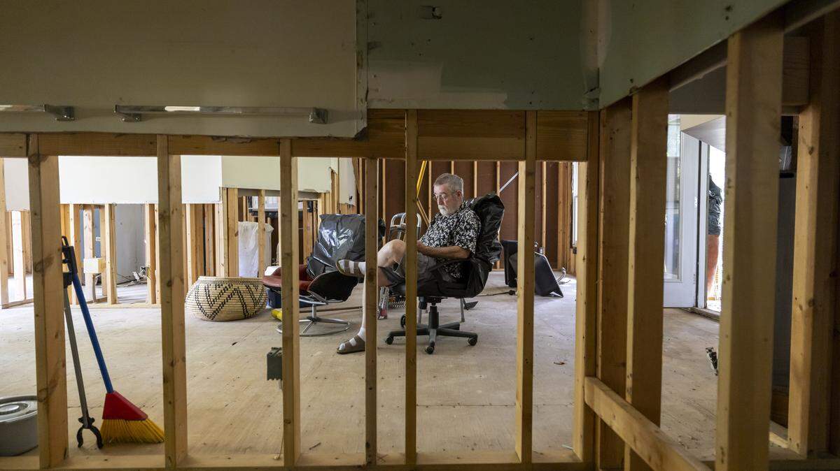 Peter Burke sits in the living room of his flood damaged home in the Weatherhill Pointe neighborhood of Carrboro, N.C., on Friday Aug. 15, 2025. Burke is waiting for contractors to install new dry wall and electrical wiring so he can return to his home.