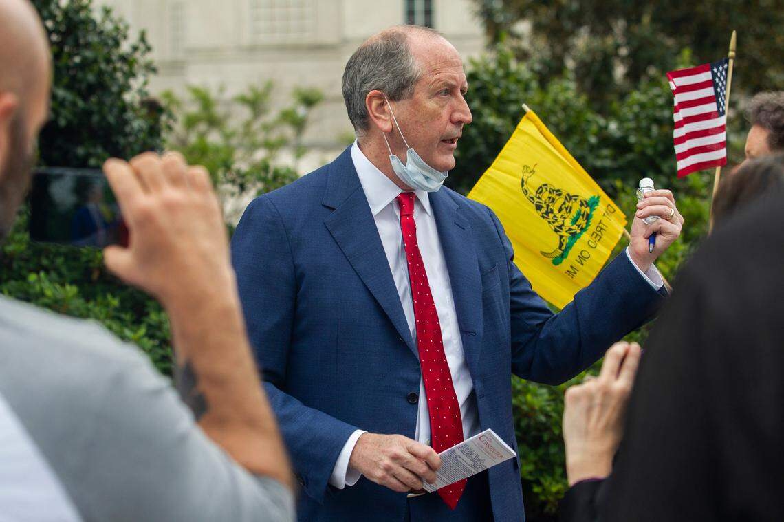 U.S. Rep. Dan Bishop holds a copy of the Constitution and a bottle of hand sanitizer while talking with constituents and reporters during a ReOpen NC protest in downtown Raleigh, N.C. Tuesday, April 21, 2020.
