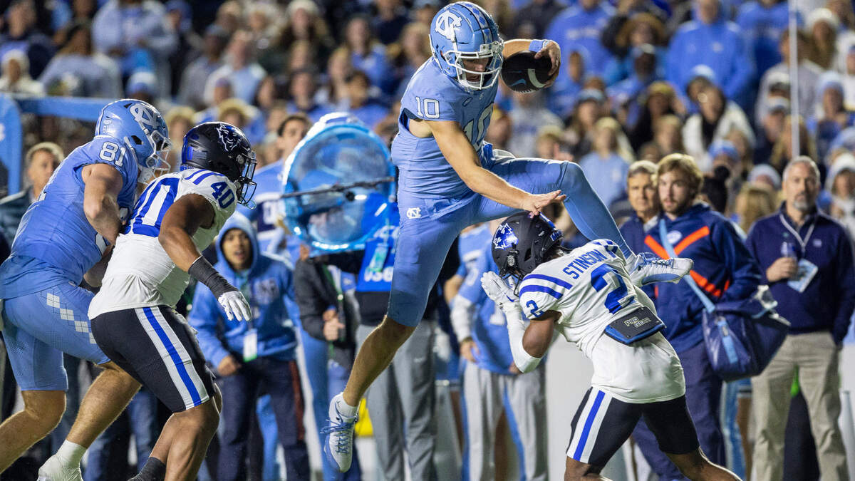 North Carolina quarterback Drake Maye (10) picks up 15-yards as he hurdles over Duke’s Jaylen Stinson (2) to set up a touchdown in the third quarter on Saturday, Nov. 11, 2023 at Kenan Stadium in Chapel Hill, N.C.