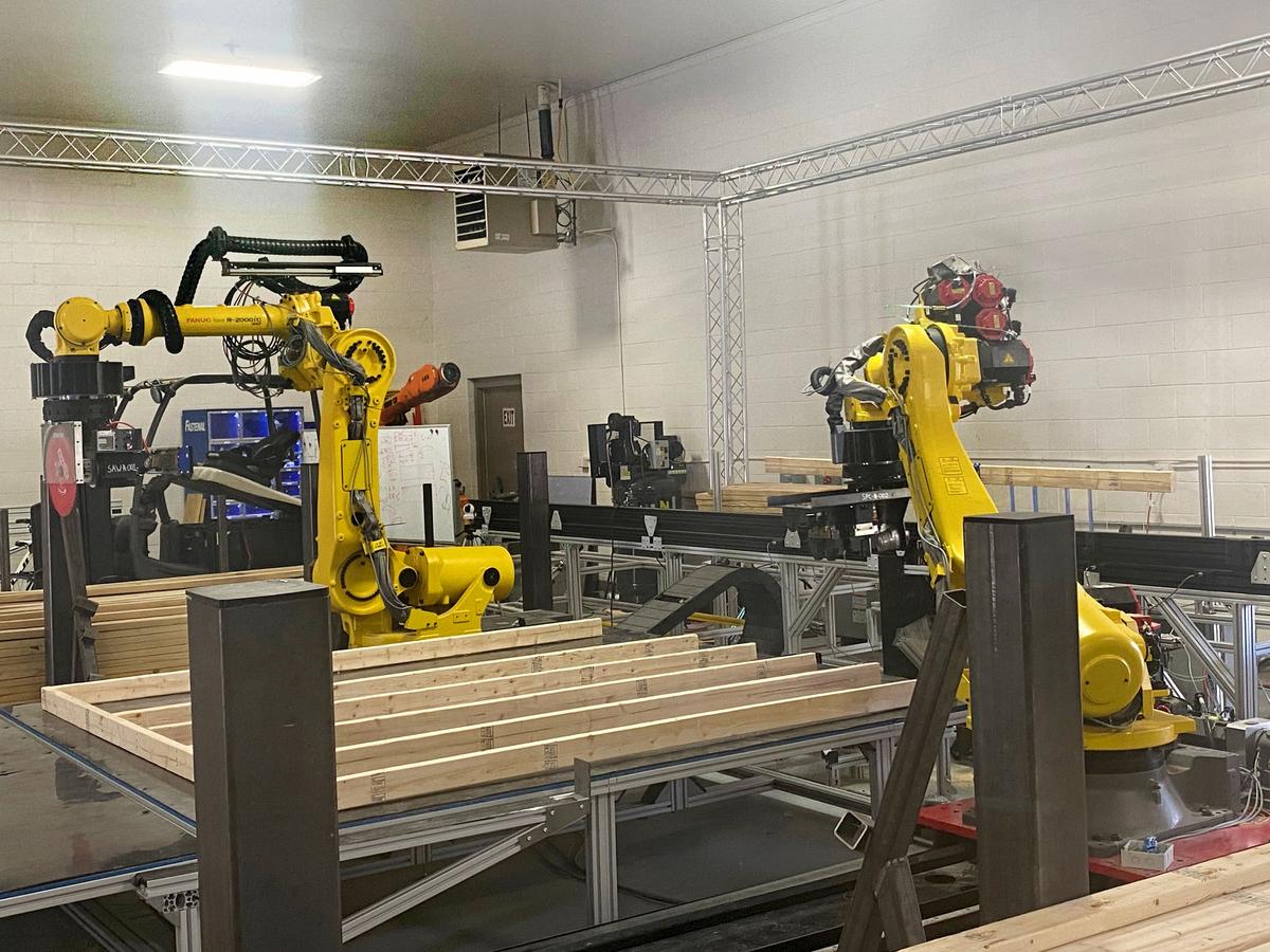 Axl and Slash maneuver fasten housing panels at BotBuilt’s research and development lab in Durham.