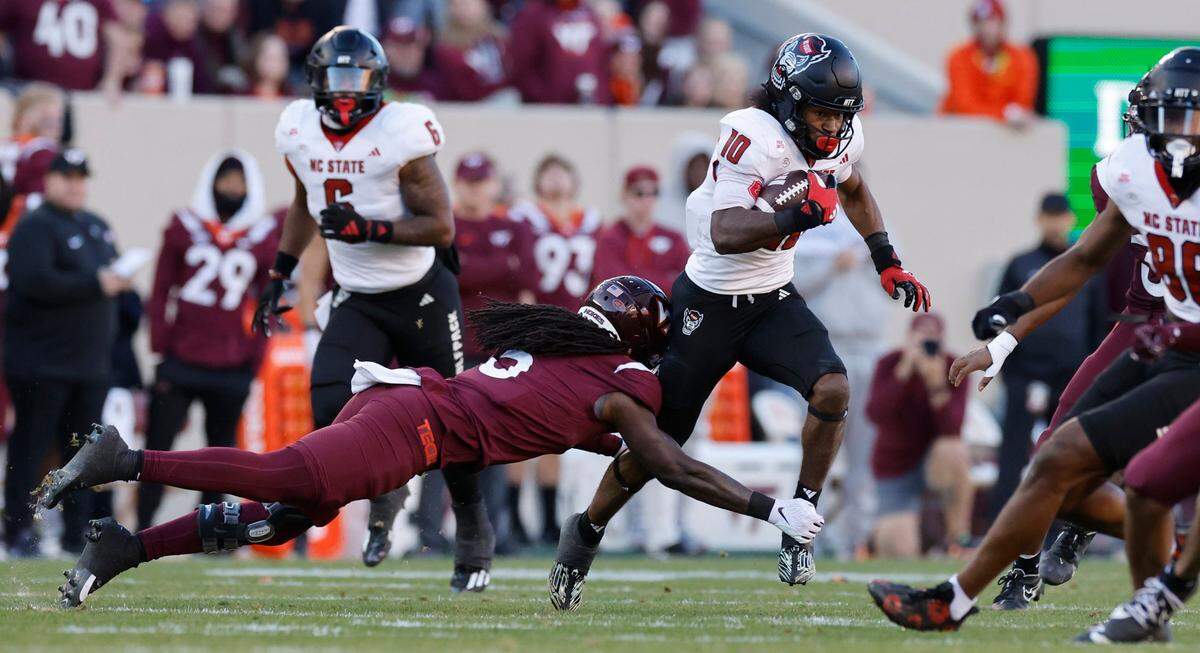 N.C. State’s KC Concepcion runs past Virginia Tech safety Nasir Peoples (5) during the first half of N.C. State’s game against Virginia Tech at Lane Stadium in Blacksburg, VA, Saturday, Nov. 18, 2023.
