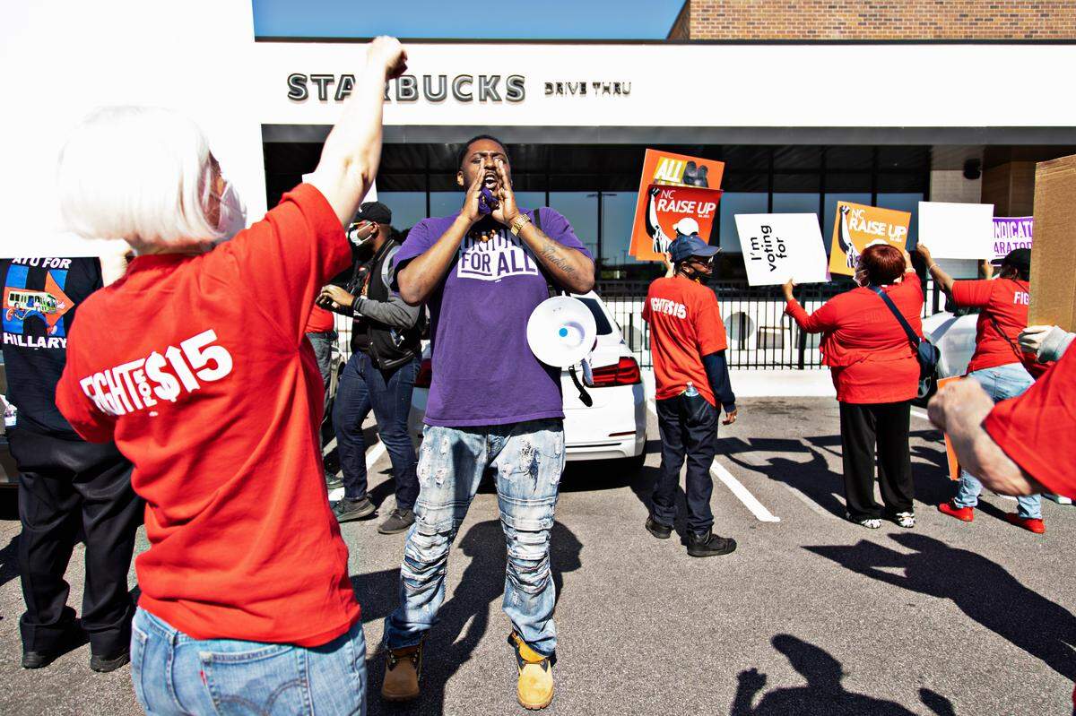 Protestors including Keith Bullard, center, with Fight for $15, leads a chant outside of the Wake Forest & Six Forks Starbucks in Raleigh on April 11, 2022, in response to the firing of vocal union leader Sharon Gilman earlier this month.
