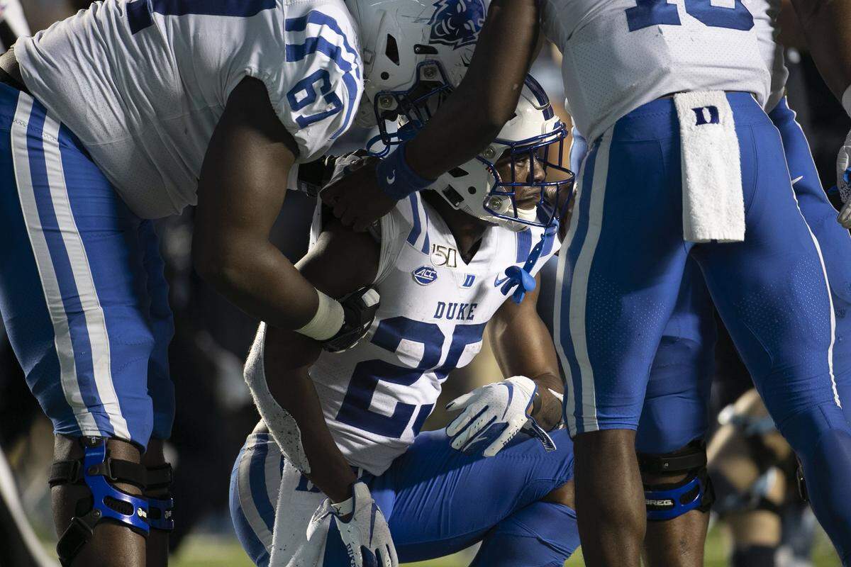 Duke’s Deon Jackson (25) is consoled by teammates Quentin Harris (18) and Rakavius Chambers (67) after he threw an interception with 14 seconds to play to secure a 20-17 victory for North Carolina on Saturday, October 26, 2019 at Kenan Stadium in Chapel Hill, N.C.