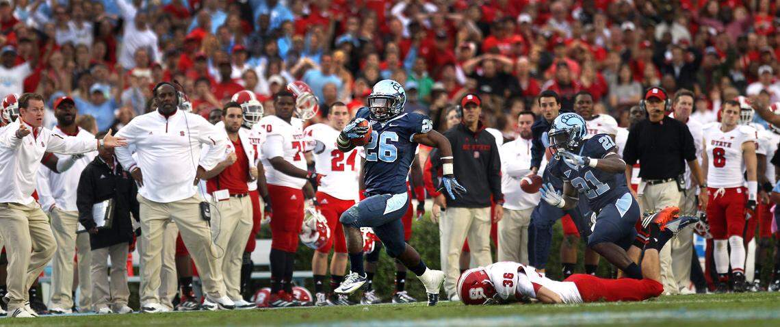 UNC’s Giovani Bernard (26) breaks away from N.C. State’s Will Baumann (36) as he races in front of the Wolfpack bench during a 74-yard punt return to score the game winning touchdown with :13 seconds to play, securing a 43-35 victory over N.C. State on Saturday October 27, 2012 at Kenan Stadium in Chapel Hill, N.C.