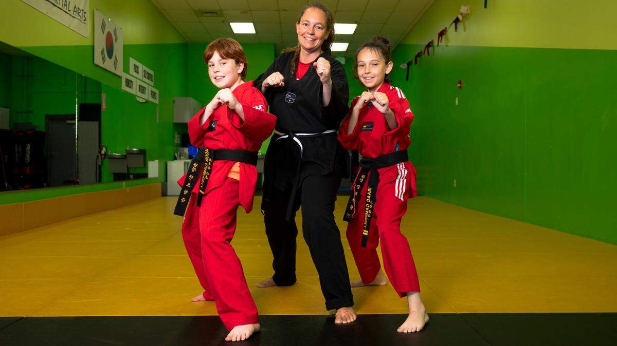 Laura Campbell and her two sons, Jacob and Isaac, pose for a portrait at Master Chang’s Martial Art Studio in Durham, N.C. on June 4, 2024. Isaac describes taekwondo as his family’s happy place.