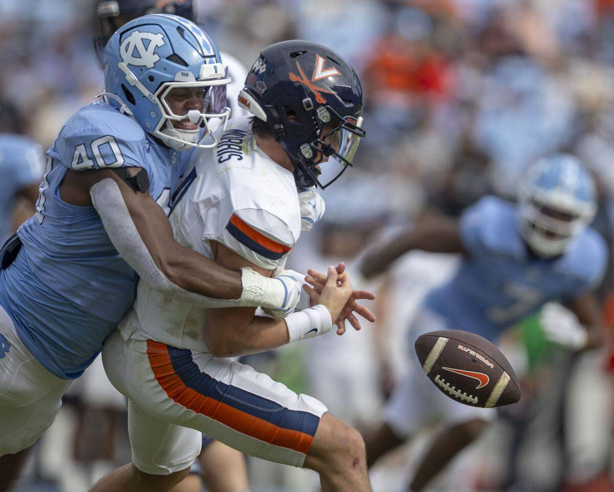 North Carolina linebacker Tyler Thompson (40) sacks Virginia quarterback Chandler Morris (4), and forces a fumble, in the fourth quarter on Saturday, October 25, 2025 at Kenan Stadium in Chapel Hill, N.C.