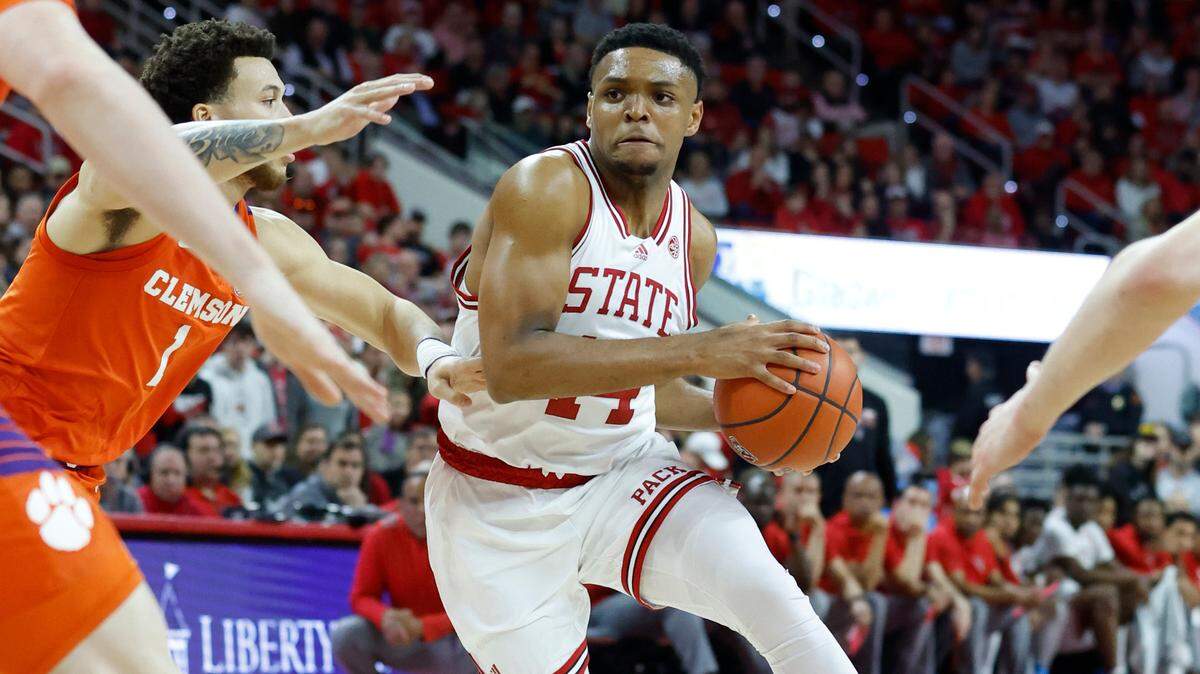N.C. State’s Casey Morsell (14) drives by Clemson’s Chase Hunter (1) during the first half of N.C. State’s game against Clemson at PNC Arena in Raleigh, N.C., Saturday, Feb. 25, 2023.