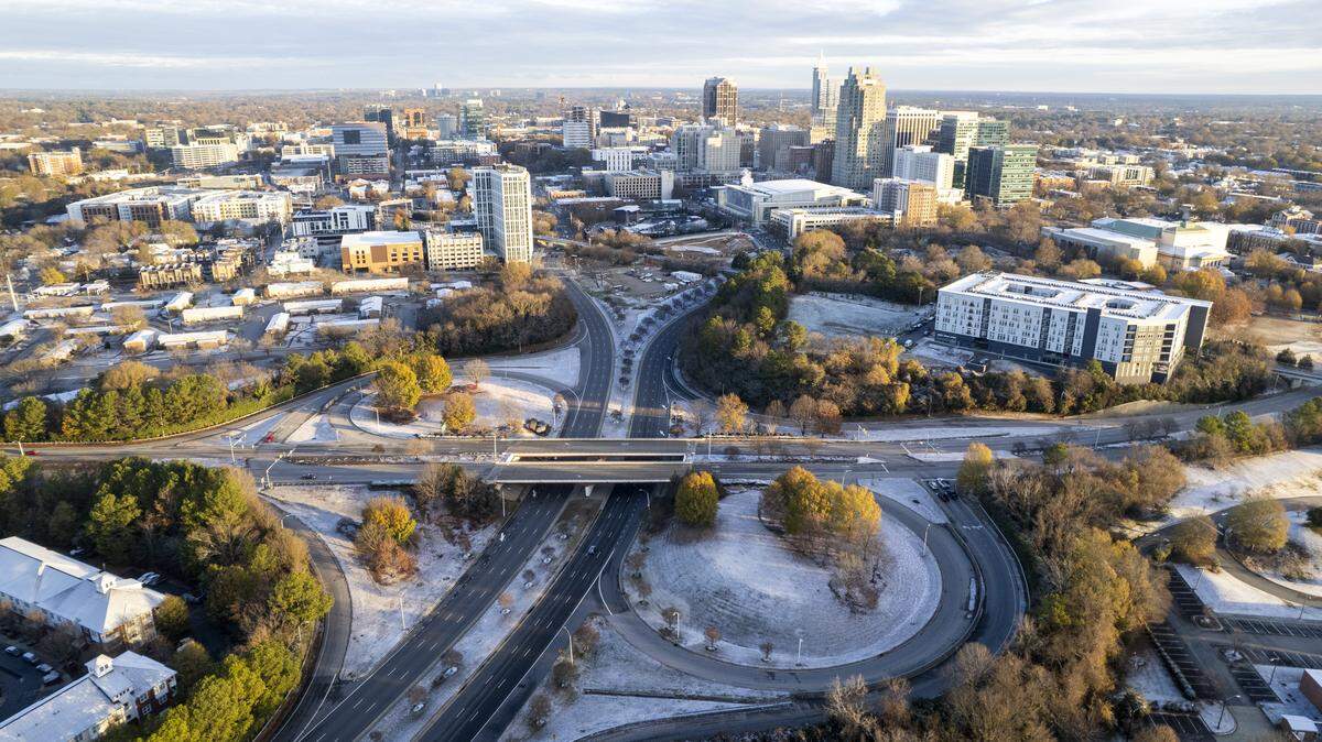 A dusting of snow accumulated overnight as the morning sun warms downtown Raleigh on Tuesday, Dec. 9, 2025. Area public schools canceled classes for the second day in a row.