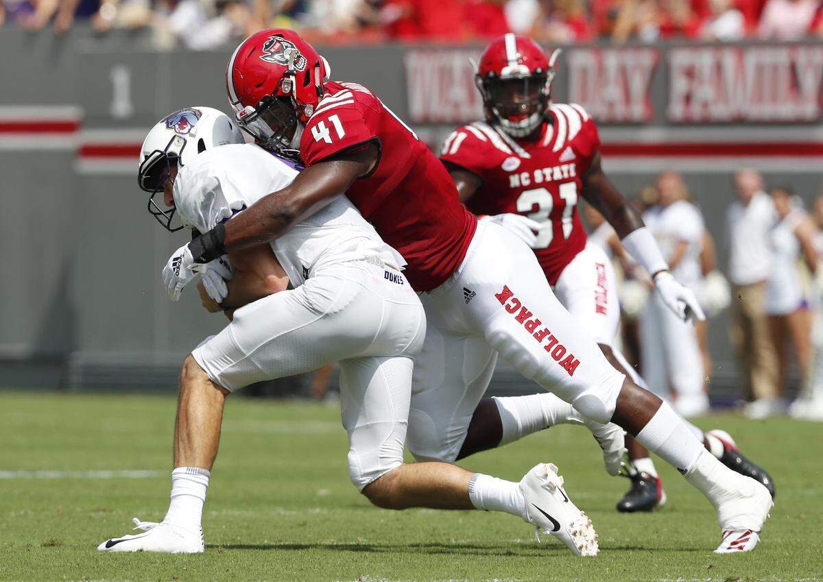 N.C. State linebacker Isaiah Moore (41) wraps up JMU quarterback Ben DiNucci (6) after he scrambled for yards during the first half of N.C. State’s game against James Madison University at Carter-Finley Stadium Saturday, Sept. 1, 2018.