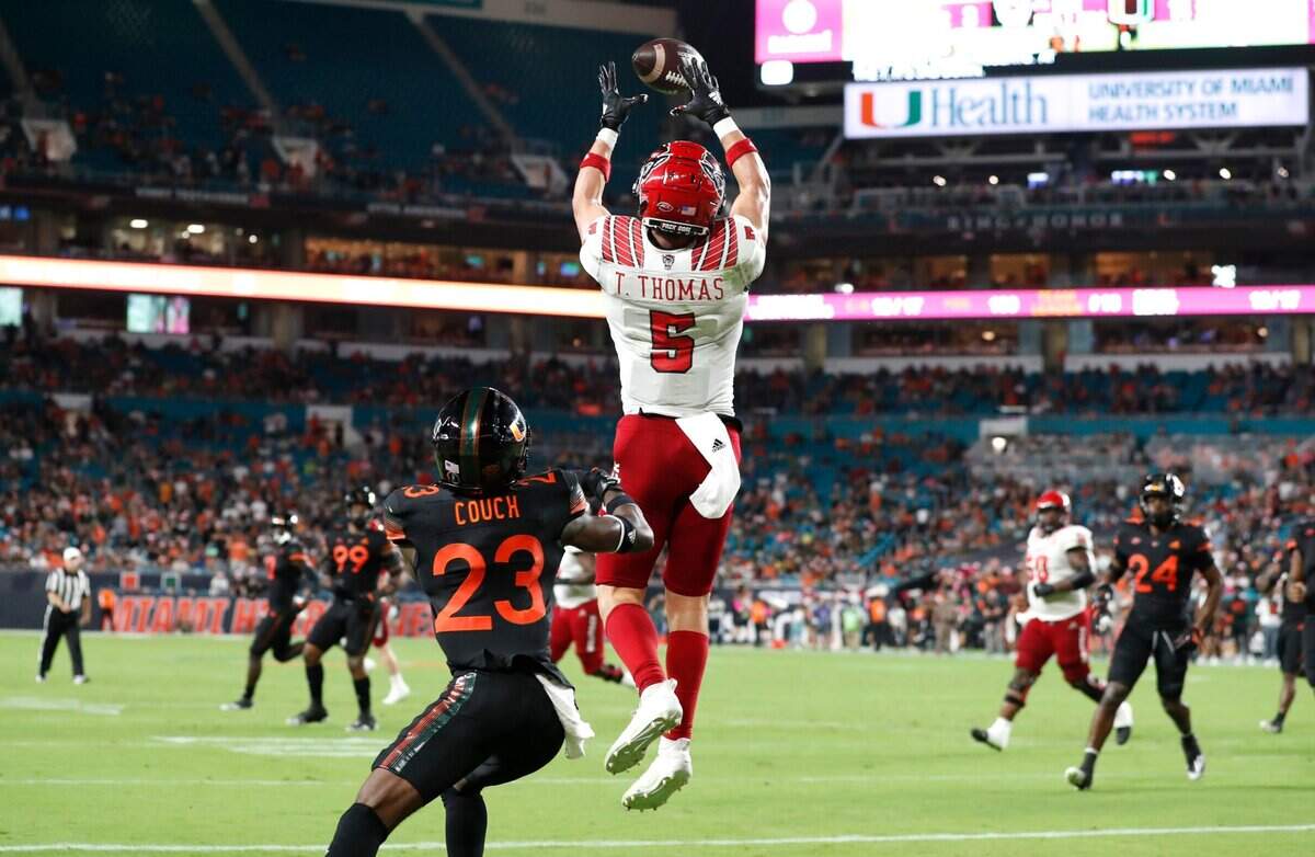 N.C. State wide receiver Thayer Thomas (5) pulls in a seven-yard touchdown reception during the first half of N.C. States game against Miami at Hard Rock Stadium in Miami Gardens, Fla. Saturday, Oct. 23, 2021. Miami cornerback Te’Cory Couch (23) defends.