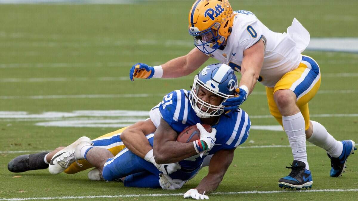 Duke’s Mataeo Durant (21) is tackled by Pittsburgh’s SirVocea Dennis, left, and John Petrishen (0) during the first half of an NCAA football game in Durham, N.C., Saturday, Nov. 6, 2021.