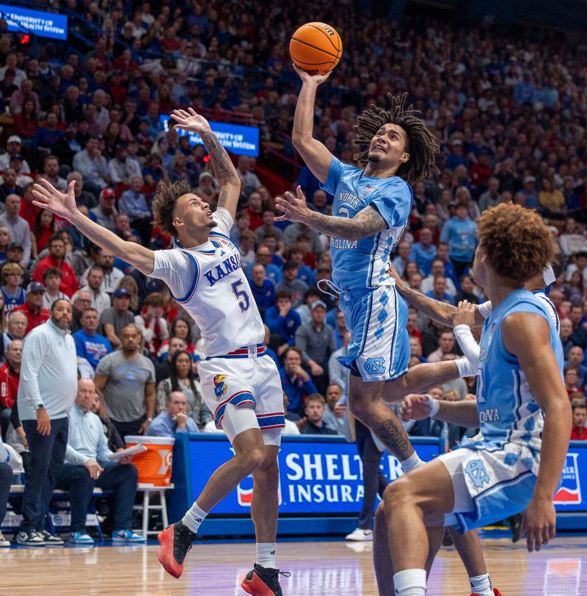 North Carolina guard Elliot Cadeau (3) drives to the basket against Kansas guard Zeke Mayo (5) in the second half on Friday, November 8, 2024 at Allen Fieldhouse in Lawrence, Kansas.