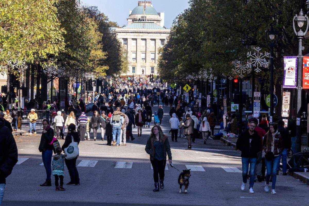 Parade goers disperse after the Raleigh Christmas parade was canceled when a truck pulling a float lost control and hit a parade participant near the intersection of Hillsborough Street and Boylan Avenue Saturday, Nov. 19, 2022.
