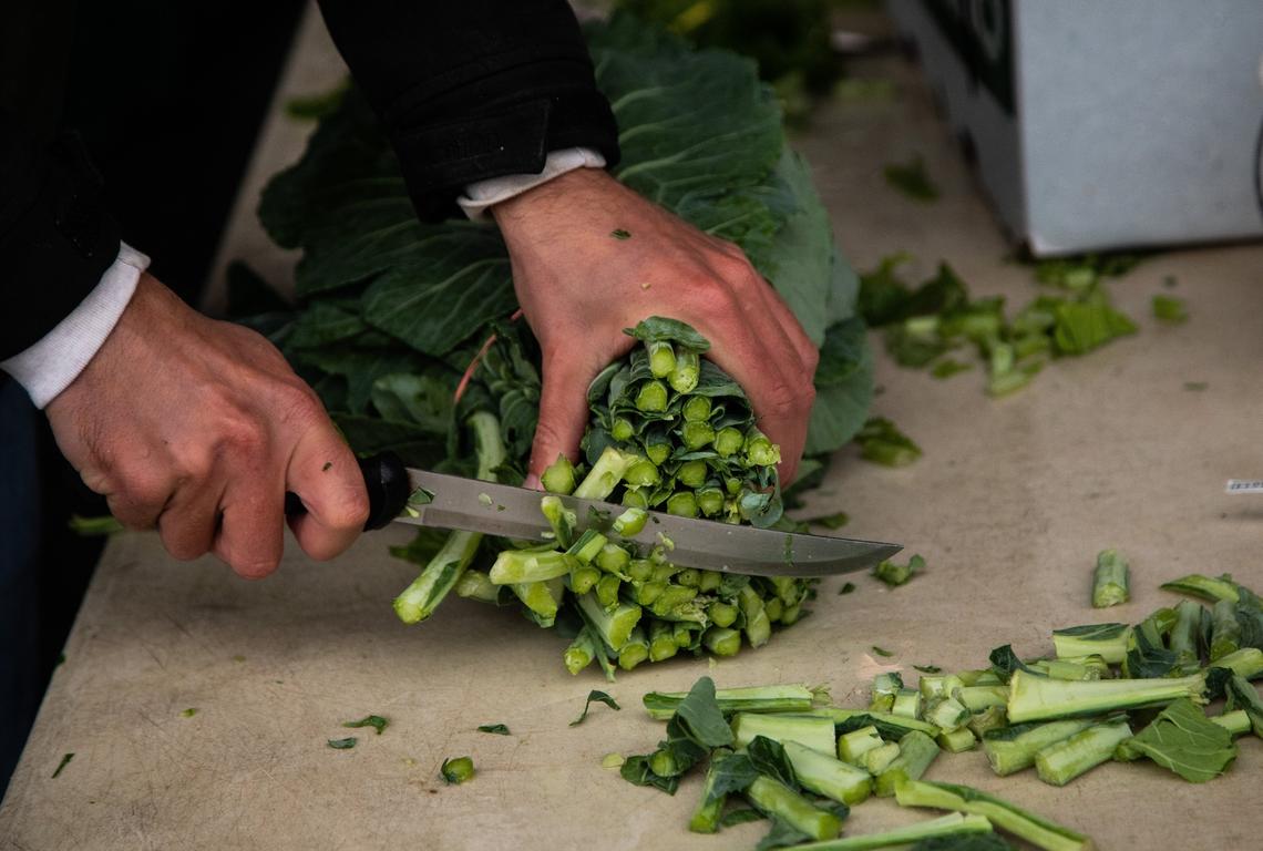 Jay Tart of Tart Farms preps collard greens for sale at the State Farmers Market in Raleigh on Wednesday. Whole-head collards will not be available at the market this Thanksgiving.