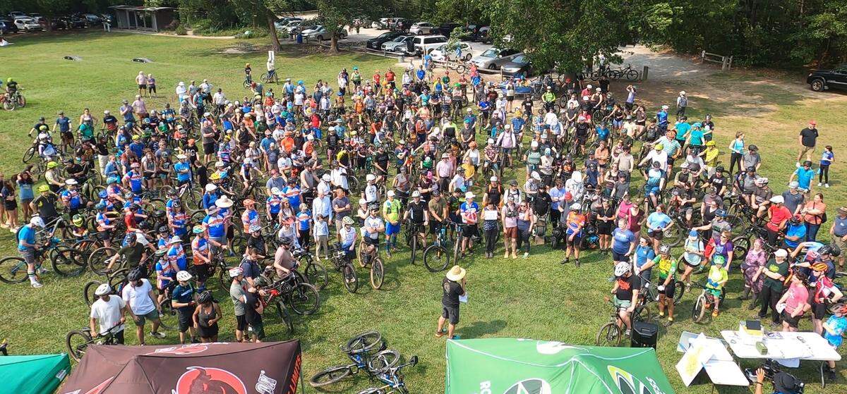 Off-road cyclists gather at Lake Crabtree County Park on Saturday May 31, 2025, before one final group ride on the trails there. Wake County closed the trails the following day, a month before its lease with Raleigh-Durham International Airport expired.