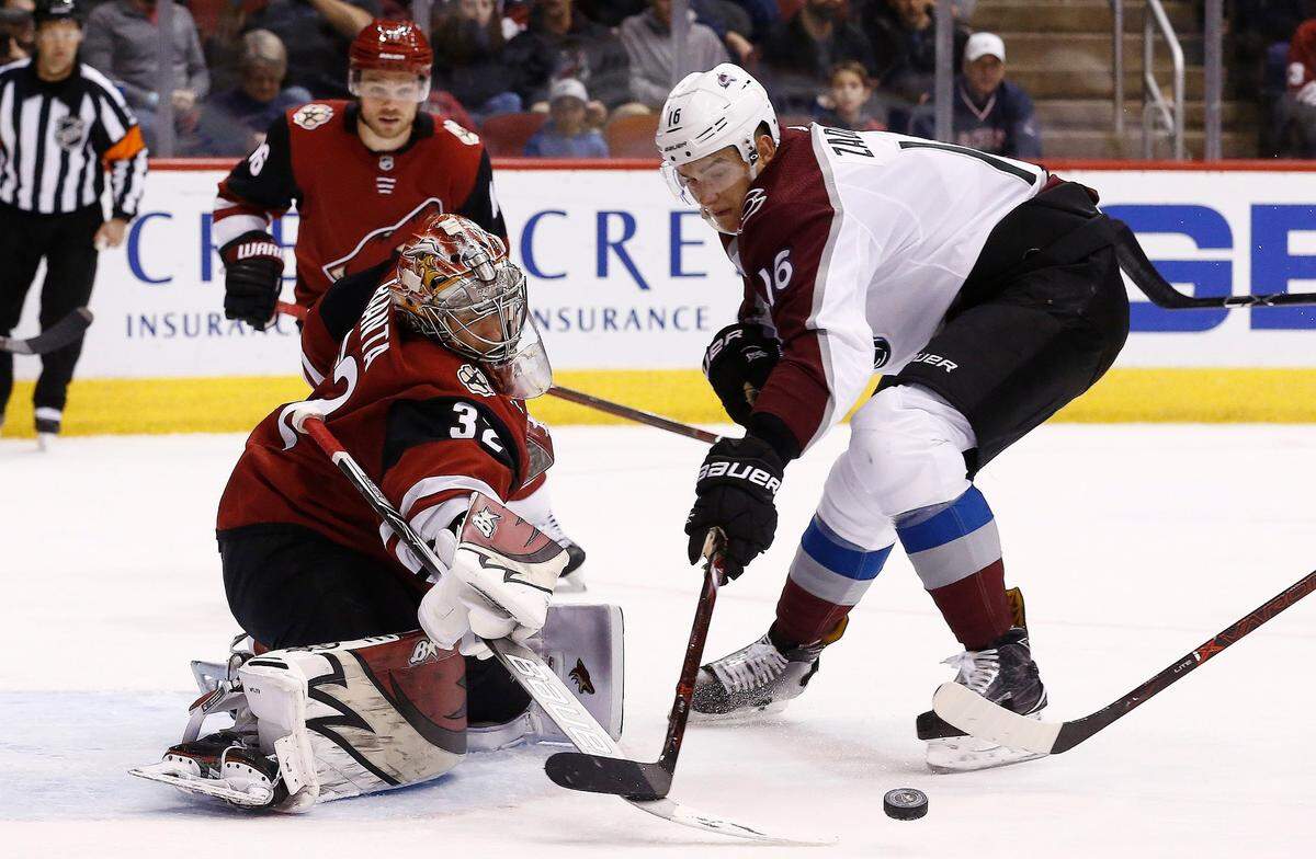Arizona Coyotes goalie Antti Raanta (32) makes a save on a shot by Colorado Avalanche defenseman Nikita Zadorov (16) as Coyotes left wing Max Domi (16) looks on during the second period of an NHL hockey game, Saturday, Dec. 23, 2017, in Glendale, Ariz. The Avalanche defeated the Coyotes 6-2. (AP Photo/Ross D. Franklin)