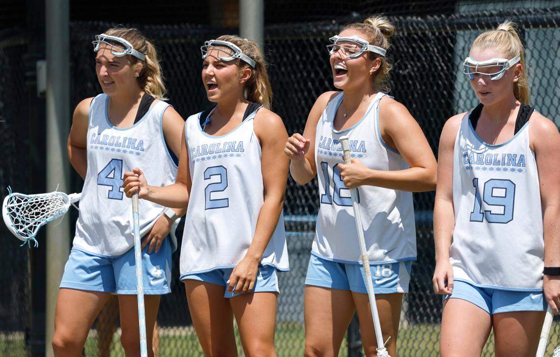 North Carolina’s Caroline Godine (4), Chloe Humphrey (2), her sister Ashley Humphrey (18), and Julia O’Connor (19) cheer on teammates during a practice at UNC on Friday, May 2, 2025.