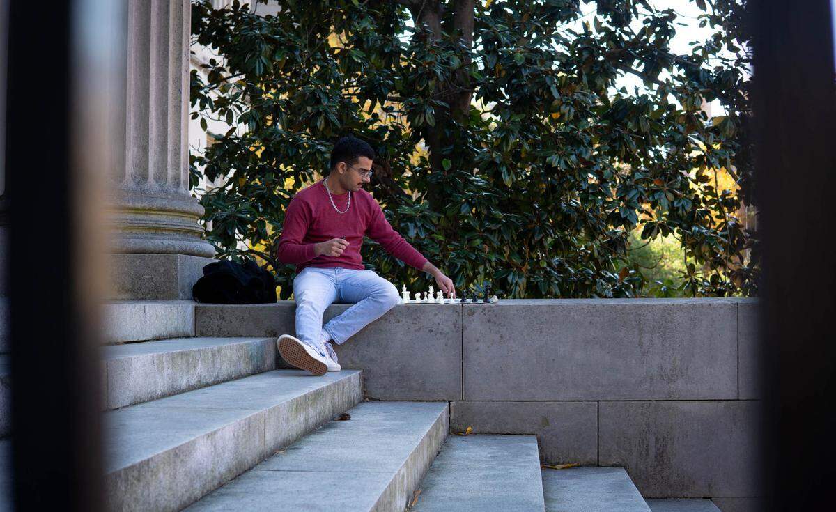 Priyav Chandna sets up his chess practice board on the steps of Wilson Library. A competitive chess player for over a decade, Chandna now dedicates his time to teaching the craft.