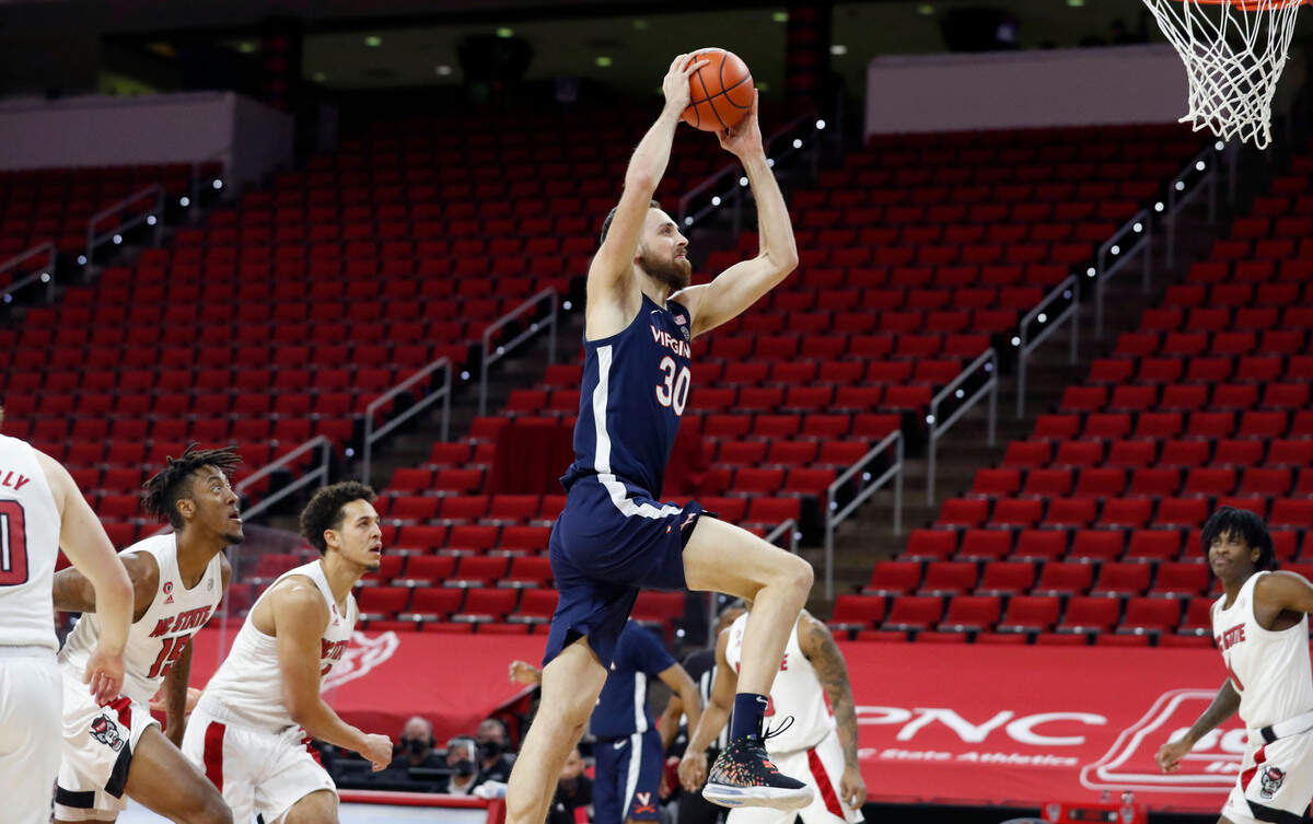 Virginia’s Jay Huff (30) heads to slam in two during the first half of N.C. State’s game against Virginia at PNC Arena in Raleigh, N.C., Wednesday, February 3, 2021.