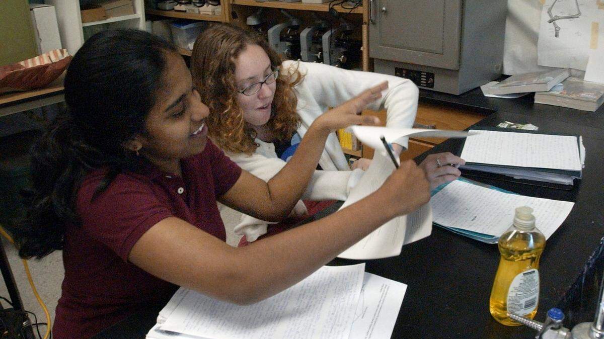 Seniors Anusha Vadlamudi, 17, (left) and Sarah Underwood, 17, share notes during a review session for the Advanced Placement Biology test during class at Chapel Hill High School in this file photo.