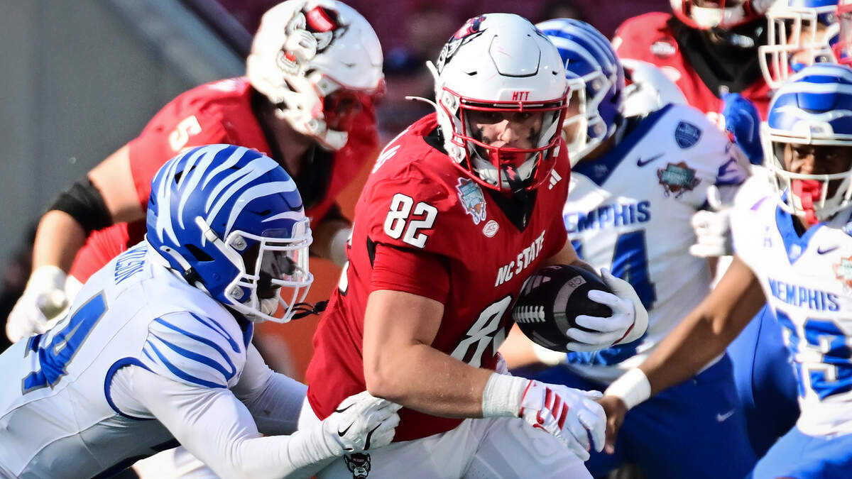 Preston Douglas (82) of the NC State Wolfpack breaks a tackle from Kamari Wilson of the Memphis Tigers in the first half during the 2025 Union Home Mortgage Gasparilla Bowl.