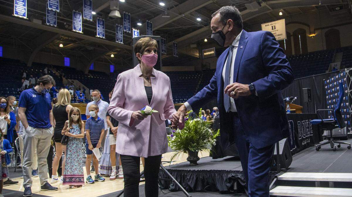 Duke University basketball coach Mike Krzyzewski holds his wife Mickie Krzyzewski’s hand as he walks off stage after announcing his retirement at the conclusion of the 2021-22 season during a press conference at Cameron Indoor Stadium Thursday, June 3, 2021. Duke associate head coach Jon Scheyer will be the coach-in-waiting before taking over the program as its next head coach in 2022, Duke announced on Wednesday.