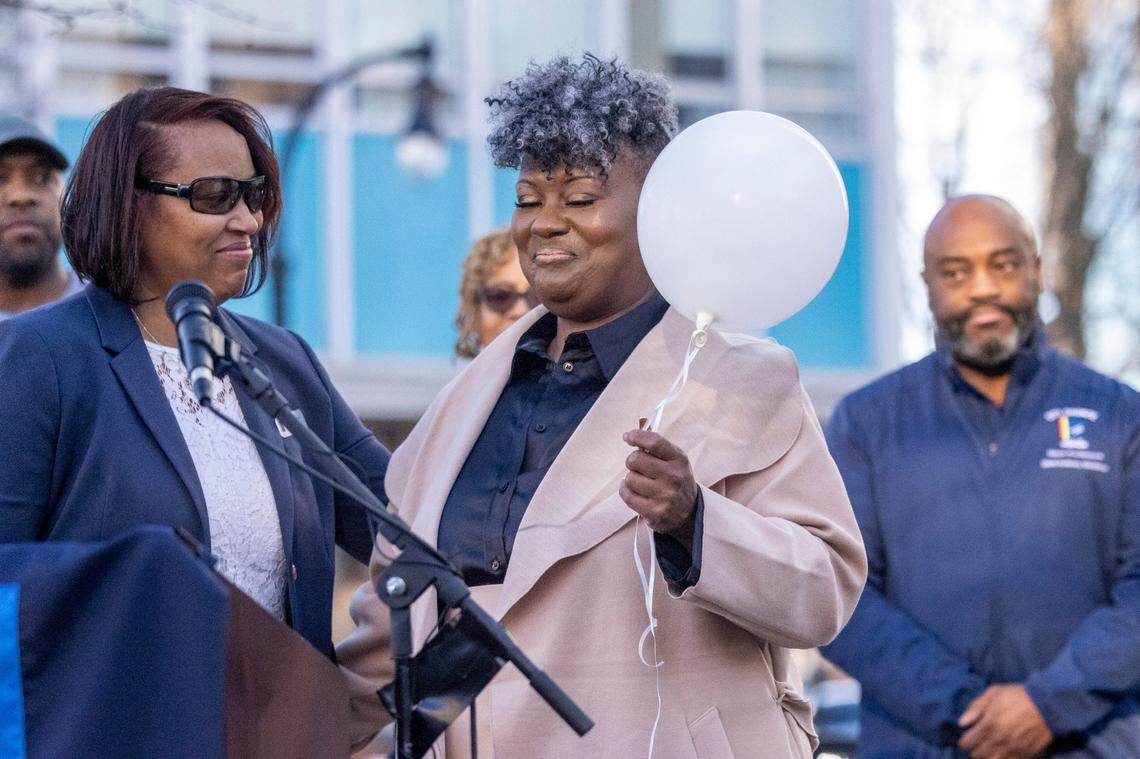 Durham City Council member DeDreana Freeman, left, gives a white balloon to Keshia Gray, a gun violence prevention advocate from Bull City United, during a Day of Remembrance for Gun-Related Homicide Victims ceremony in Durham Friday, Dec. 30, 2022.