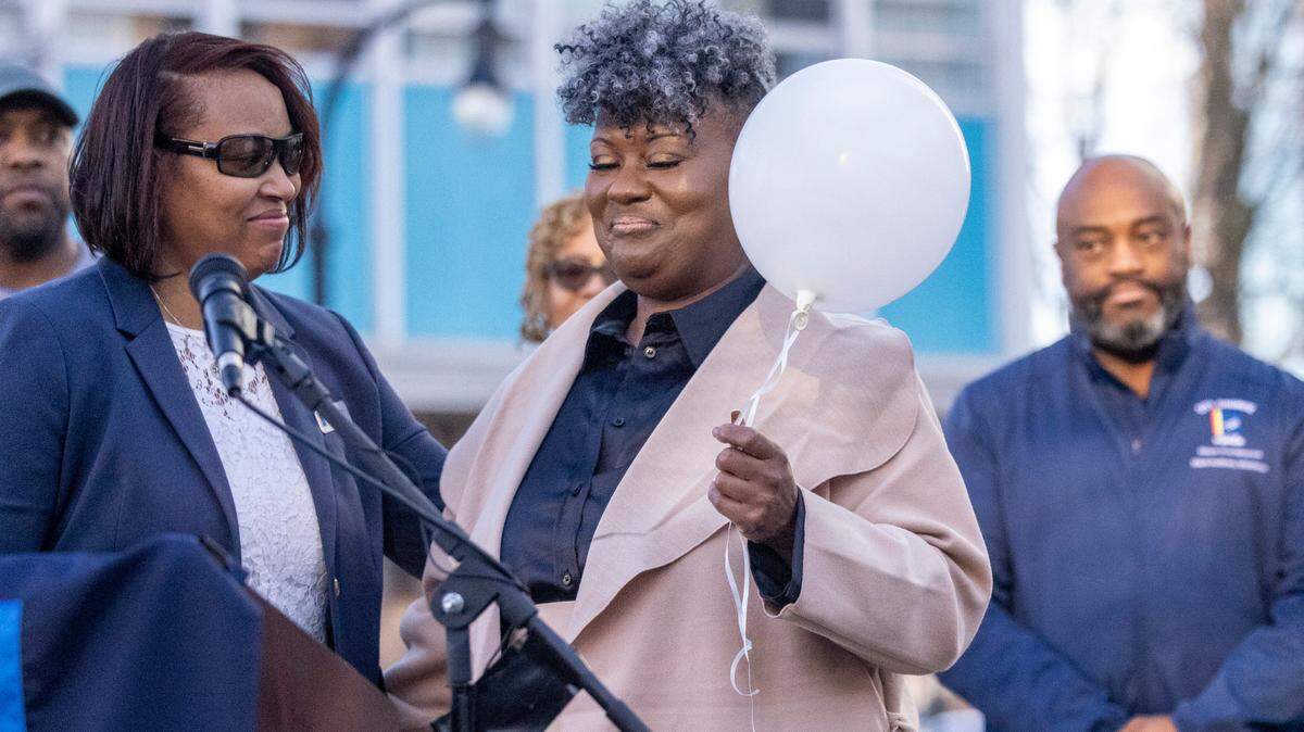 Durham City Council member DeDreana Freeman, left, gives a white balloon to Keshia Gray, a gun violence prevention advocate from Bull City United, during a Day of Remembrance for Gun-Related Homicide Victims ceremony on Dec. 30, 2022.