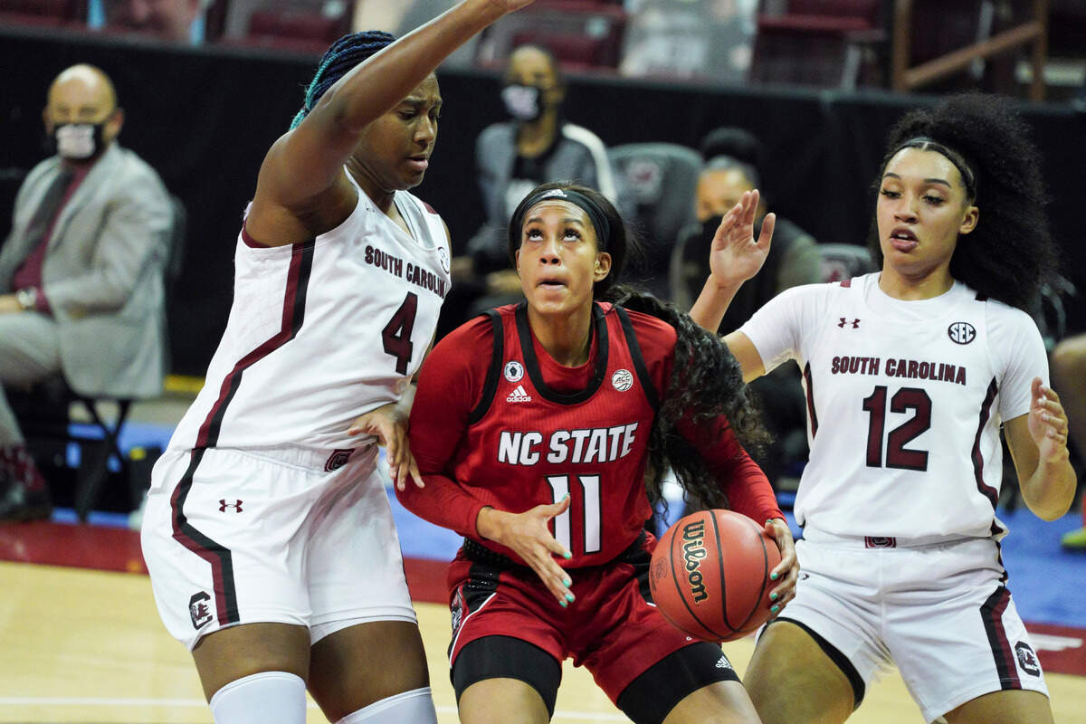North Carolina State forward Jakia Brown-Turner (11) looks for a shot against South Carolina’s Aliyah Boston (4) and Brea Beal (12) during the first half of an NCAA college basketball game Thursday, Dec. 3, 2020, in Columbia, S.C.